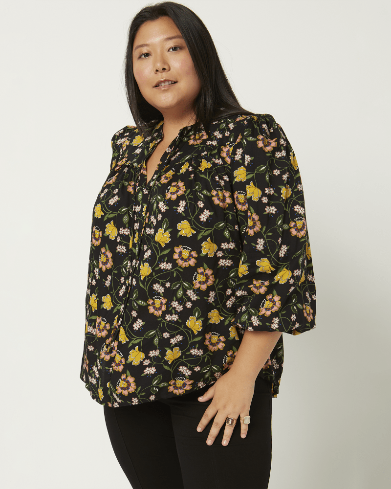 Front of a model wearing a size 1X Camilla Printed Blouse in Black / Peach by Philosophy. | dia_product_style_image_id:210720
